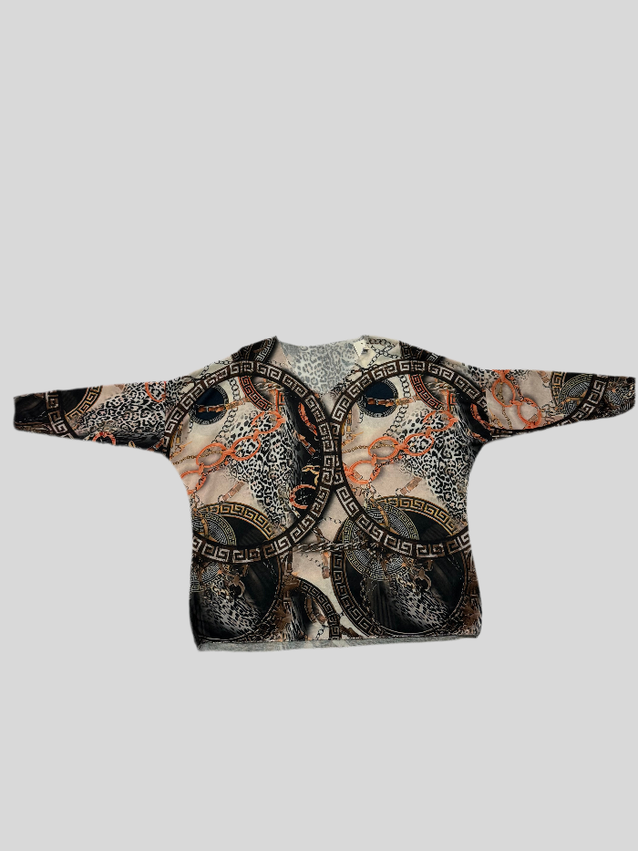 Jersey de punto fino, con cuello redondo y dibujos cenefas griegas en tonos negros, beige y naranja. Corte oversize.