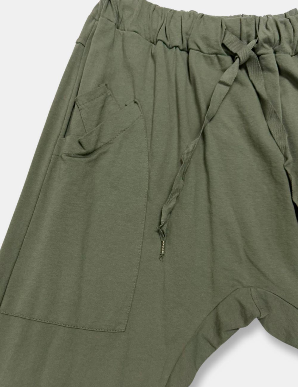 Detalle pantalones baggy color verde caqui, con bolsillos en los costados y cordón de ajuste y cierre, para mujer de talla curvy.
