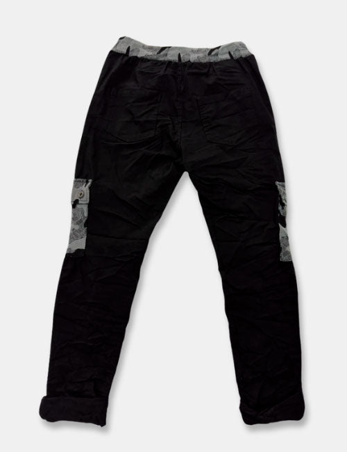 Pantalones baggy en colores negro y gris con estampado de camuflaje. Cierre con cordón ajustable y cintura elástica. Bolsillos.