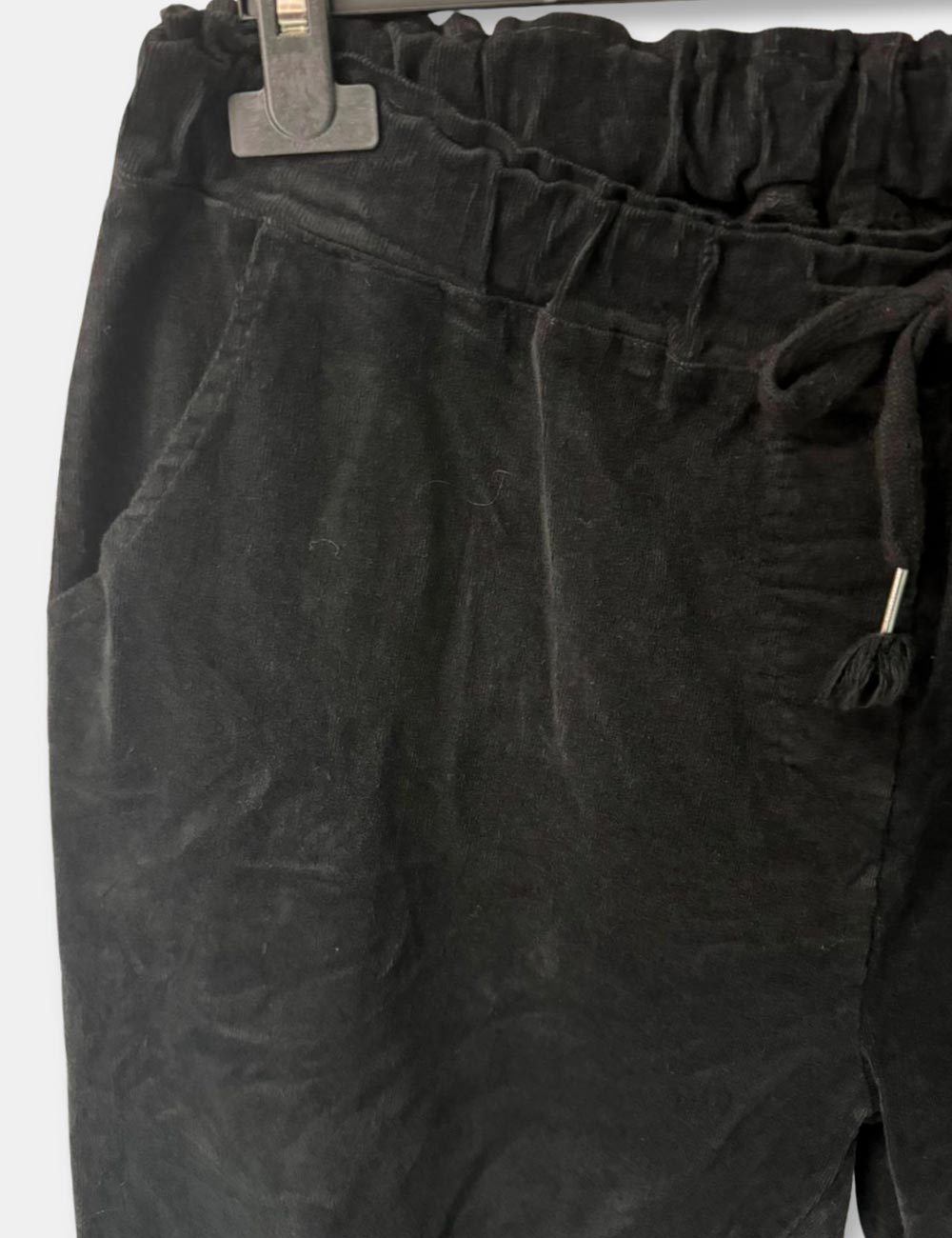 Detalle de pantalones de pana color negro, con cordón ajustable y bolsillos de talla curvy para mujer.