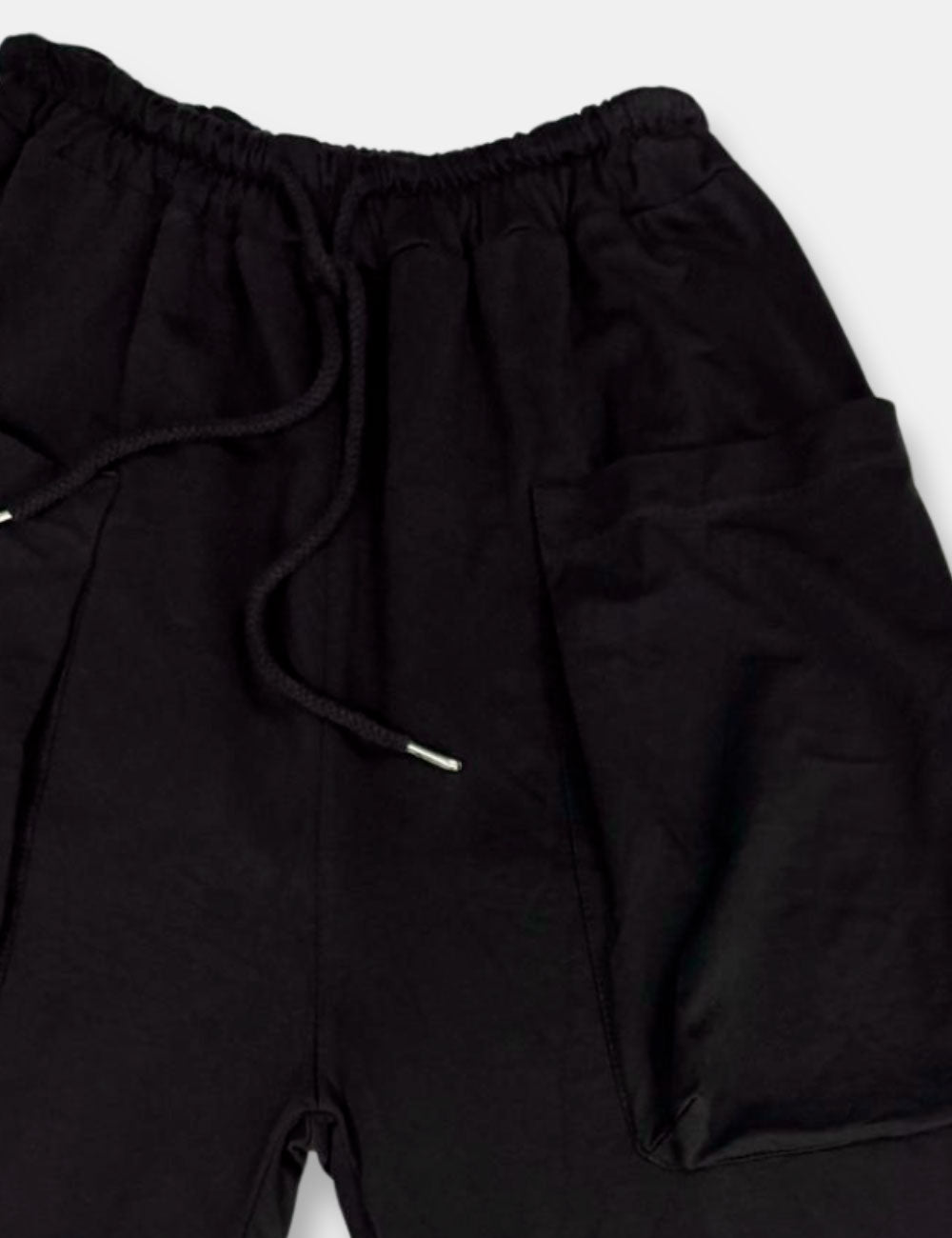 Detalle pantalones baggy negros con bolsillos, cintura elástica y cordón de ajuste para mujer de talla curvy.