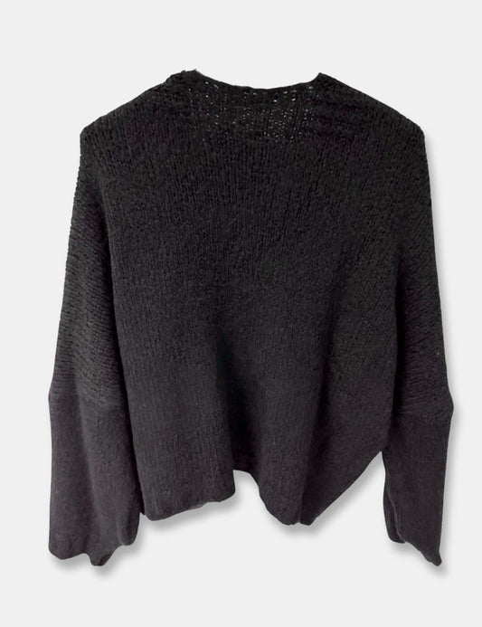 Espalda de chaqueta de punto color negro y cierre con botón para mujer de talla curvy.