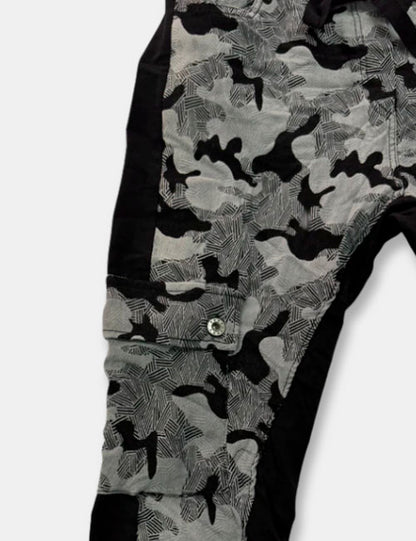 Detalle pantalones baggy en colores negro y gris con estampado de camuflaje. Cierre con cordón ajustable y cintura elástica. Bolsillos.