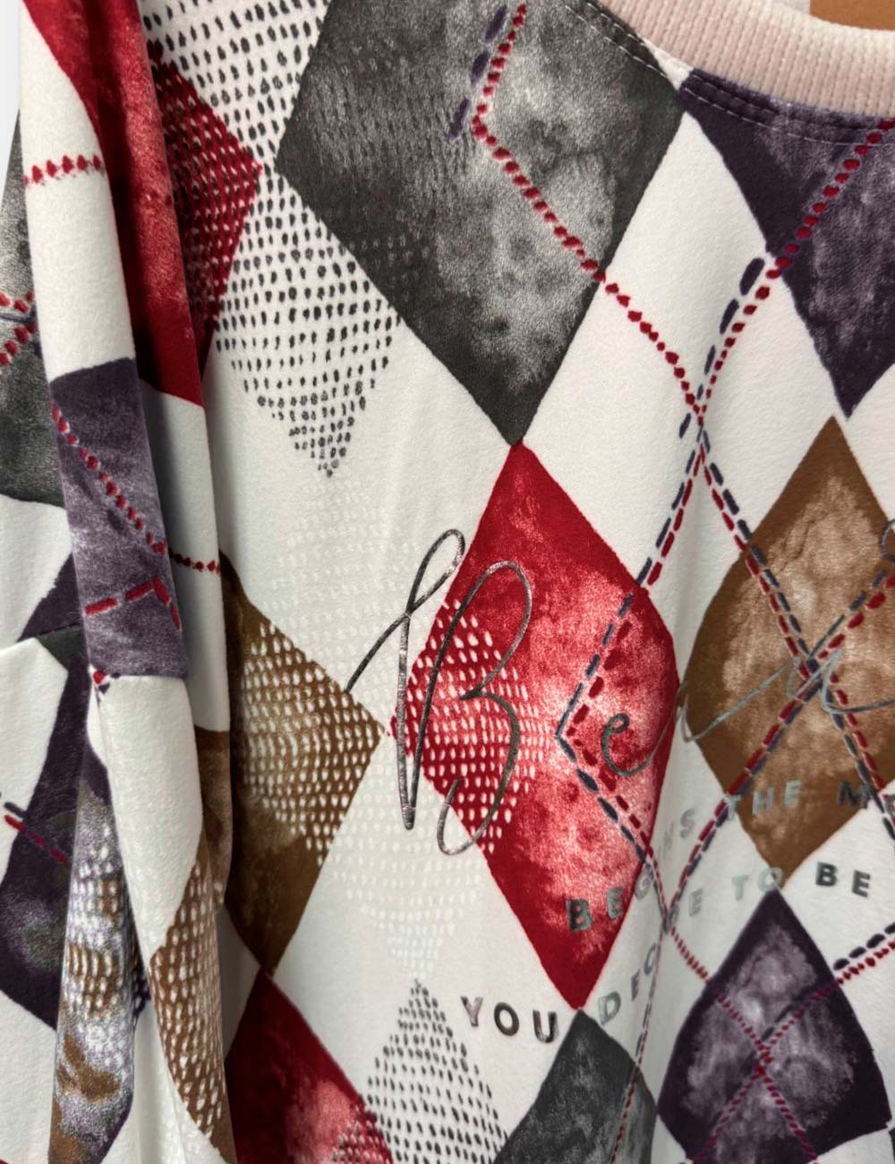 Detalle de sudadera con cordón ajustable y estampado de rombos para mujer talla curvy.