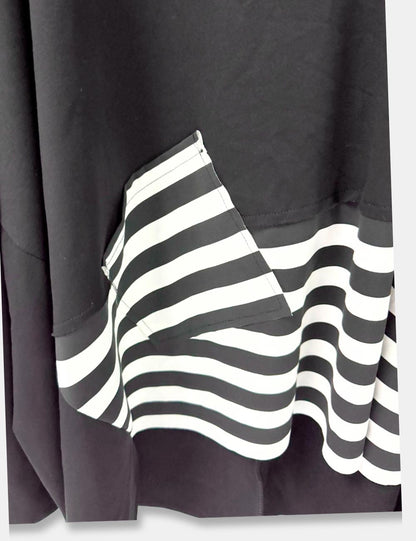 Detalle sudadera color negro, con detalle de faldón y parche en rayas blancas y negra. Abertura lateral. Talla curvy.
